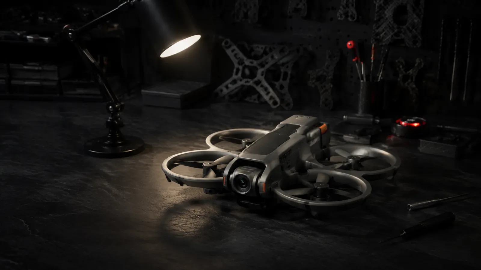 Drone DJI Avata 2 com proteções integradas de hélice apoiado sobre bancada escura de testes técnicos