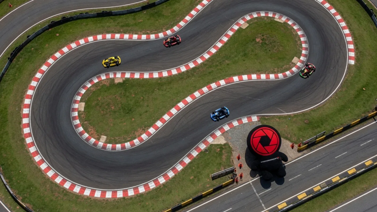 Circuito automobilístico visto de cima com traçado geométrico em asfalto e zebras sinalizadas