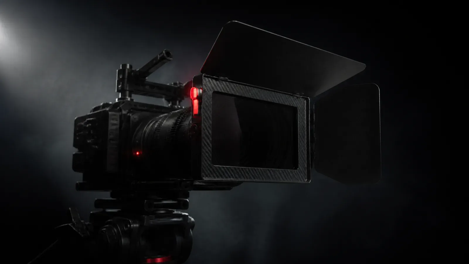 Câmera de cinema digital com matte box de fibra de carbono e filtro óptico IRND montado em estúdio sob iluminação chiaroscuro com indicador vermelho aceso