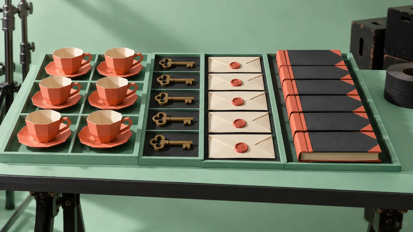 Mesa de contra-regra em escultura de papel com adereços de cena organizados em compartimentos